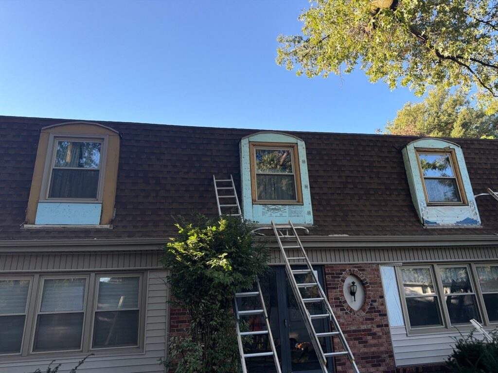 Dormers being re-sided on a mansard-style roof in Omaha, NE